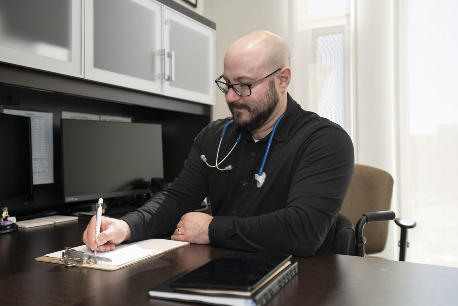 A primary care professional working on patient sheets